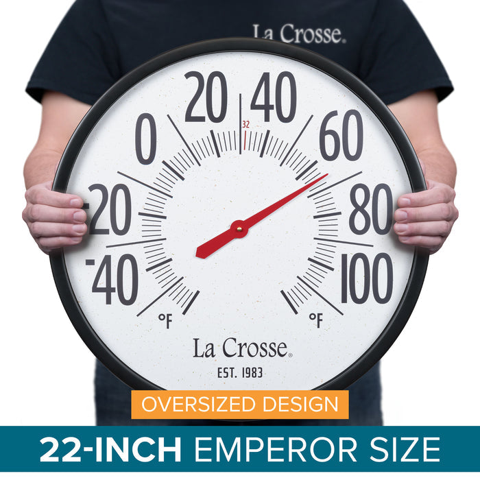 Dimension image of the 104-3056 Emperor Dial Thermometer - an extra-large oversized circular indoor/outdoor analog dial thermometer measuring 22-inches. Black plastic case surrounds a speckled terrazzo white dial and 2.90-inch-tall black numbers ranging from -60 to 120 degrees Fahrenheit. La Crosse logo and “1983” logo are located below the center of dial