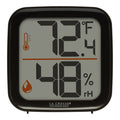 Head-on image of the 302-1407B Thermometer with Temperature and Humidity - Black. The thermometer features a black square case and a digital screen with large temperature and humidity readings. Next to the digits are corresponding temperature and humidity icons in orange.