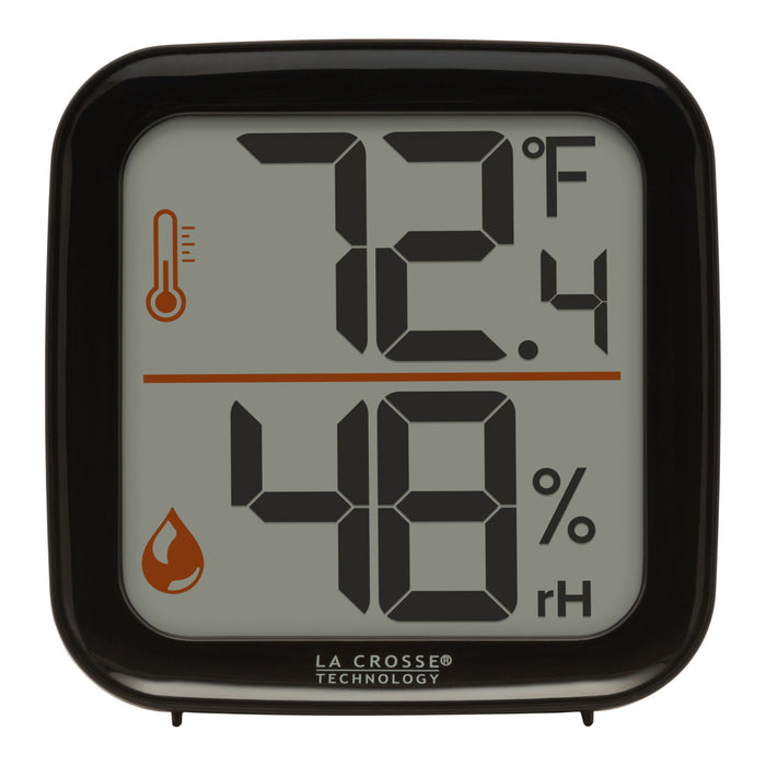 Head-on image of the 302-1407B Thermometer with Temperature and Humidity - Black. The thermometer features a black square case and a digital screen with large temperature and humidity readings. Next to the digits are corresponding temperature and humidity icons in orange.
