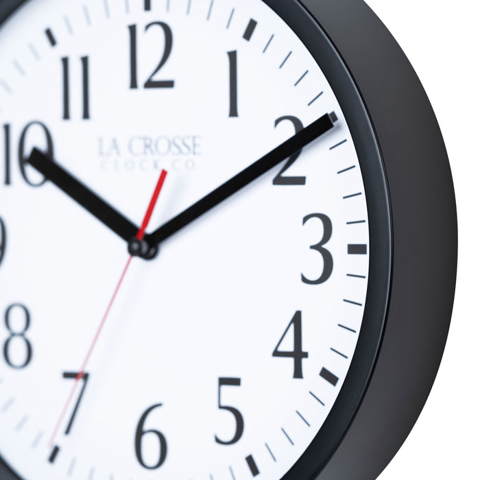 Close-up image of the frame detail of the 404-3020B-4TZ Four Pack 8-inch Basic Wall Clock with City Plaques. The clock features a black frame with a white clock face, black numbers, black hour and minute hands, and a red second hand.