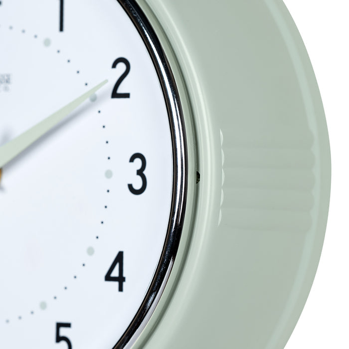 Close-up frame image of the 404-3024PH 9.5-inch Diner Wall Clock - Pistachio. The clock features an off-white dial with black numbers, pistachio hour dots, pistachio hour and minute hands, and a silver accent second hand set within a vintage-retro pistachio green frame.