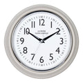Head-on image of the 404-3024TP 9.5-inch Diner Clock – Taupe. The clock features a retro-style taupe frame with a white dial, chrome bezel, black numbers and minute markings, black metal hands, and a silver second hand.