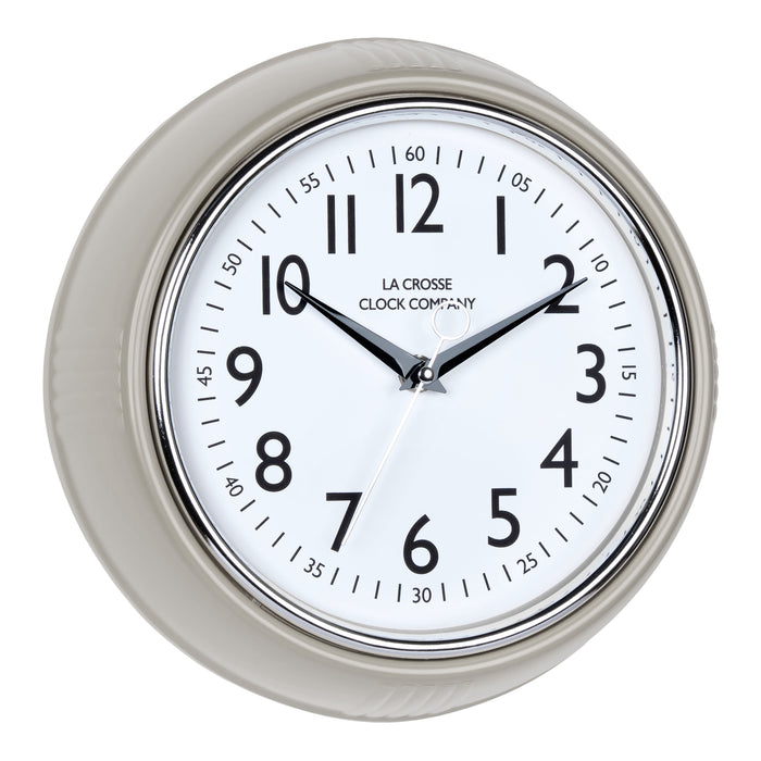 Right-facing image of the 404-3024TP 9.5-inch Diner Clock – Taupe. The clock features a retro-style taupe frame with a white dial, chrome bezel, black numbers and minute markings, black metal hands, and a silver second hand.
