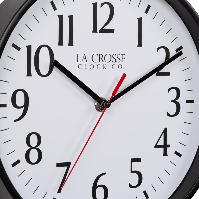 Close-up image of the dial of the 404-3025B 10-inch Basic Decor Wall Clock with a Black frame, white dial with black numbers, hour, and minute hands, and a red second hand