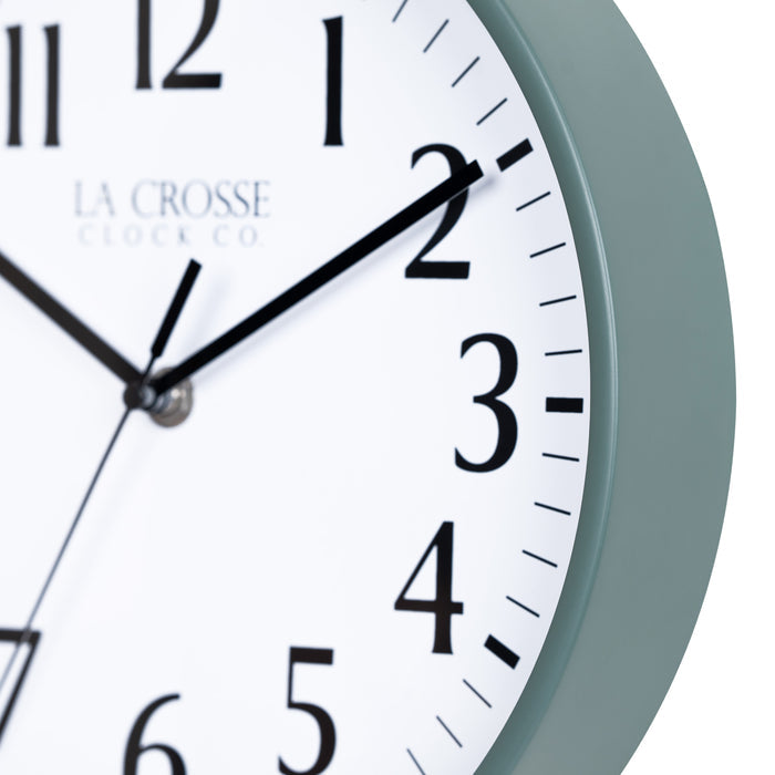 Close-up image of the Sage Green frame of the 404-3025G 10-inch Basic Decor Wall Clock with a white dial,  black numbers, hour, minute, and second hands