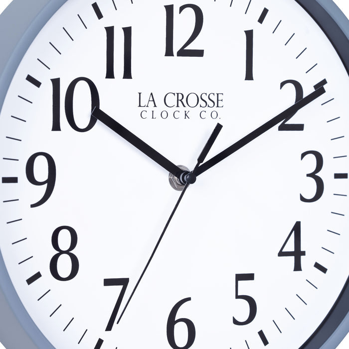 Close-up image of the dial of the 404-3025GB 10-inch Basic Decor Wall Clock with a gray blue frame, white dial with black numbers, hour, minute, and second hands.