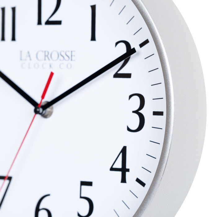 Close-up image of the Silver frame of the 404-3025S 10-inch Basic Decor Wall Clock with a white dial, black numbers, hour, minute hands, and a red second hand