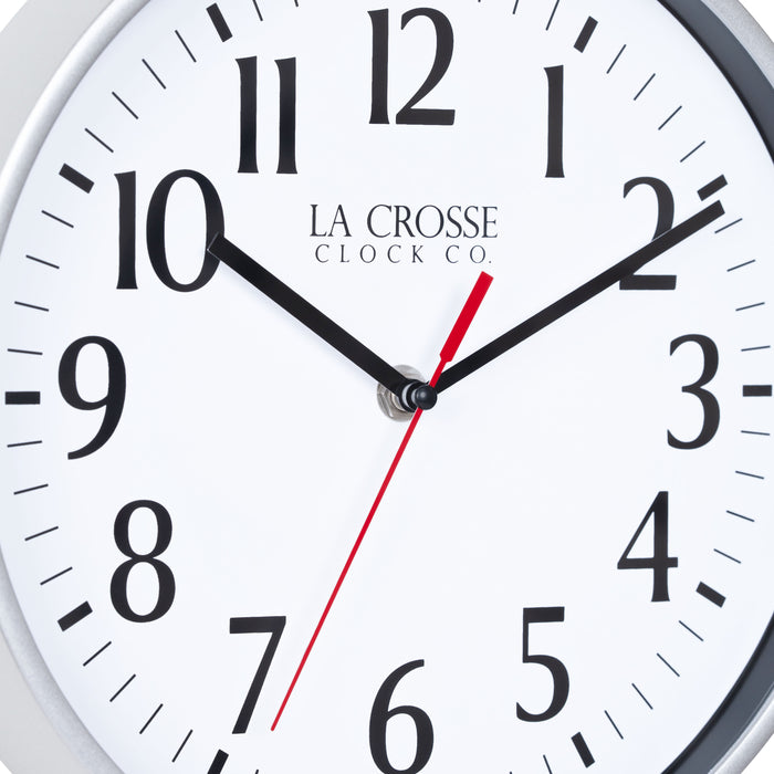 Close-up image of the dial of the 404-3025S 10-inch Basic Decor Wall Clock with a Silver frame, white dial with black numbers, hour, and minute hands, and a red second hand
