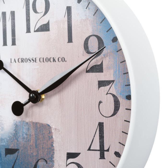 Close up image of the Brushstroke 404-3028A 11 inch wall clock highlighting the white case that surrounds a painted brush design dial in blues creams and taupe black with numbers and black metal hands