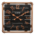 Head-on image of the 404-3412D 16-inch Foundry Metal & Wood Wall Clock - Dark. The clock features a square metal pipe frame in a copper finish, a black-stained wood slat clock face with copper-finished metal numbers and hands.