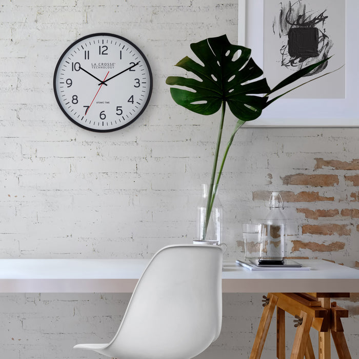 404-3730 Modern interior with a clock on the wall, white chair, and plant.