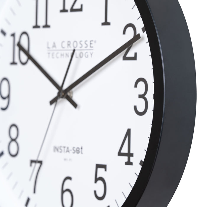 Close-up view of the frame of the 404-3836 Insta-Set Wi-Fi Wall Clock for iOS users. The clock features a black flush-mount frame, a white dial, black numbers, and black hands.
