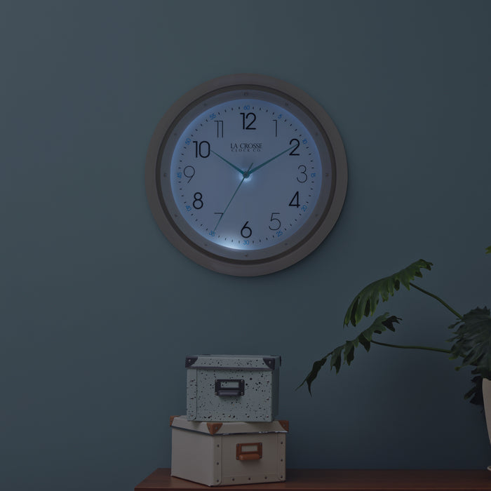 404-4525 glow in the dark wall clock night lifestyle scene with the clock lit up in the dark detailing its blue nighttime glow