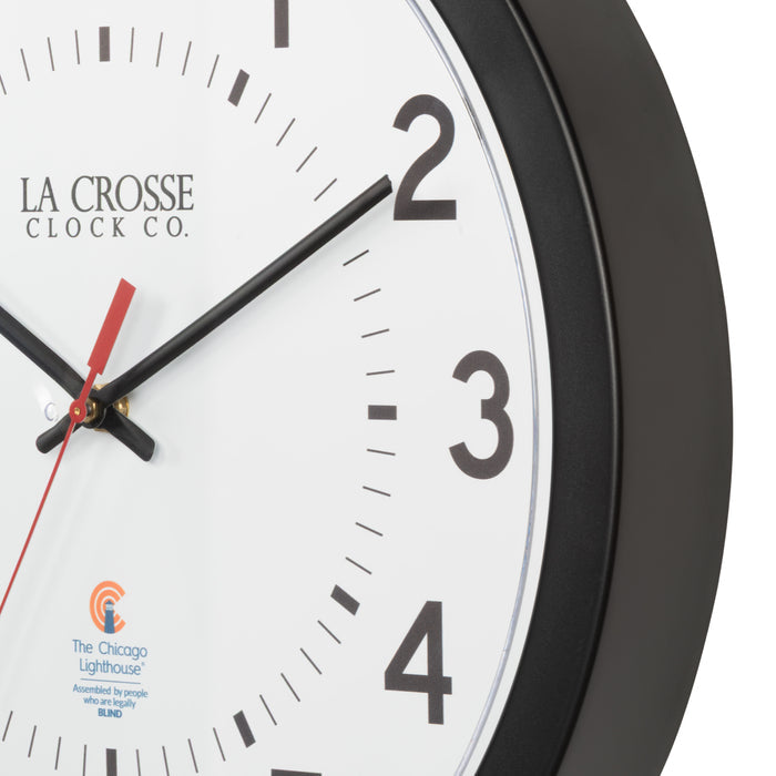 Frame closeup image of the 404-5537 14.5-inch Wall Clock  featuring a black flush mount frame, black bold numbers, black hour and minute hands, and a red second hand with two logos on the clock face, La Crosse Clock Co. and Chicago Lighthouse industries.