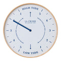 Head-on image of the 425-3831 11.8-inch Tide Wall Clock. The clock features a light wood frame, a white and tan speckled dial, blue numbers, markings, and a blue metal hand.